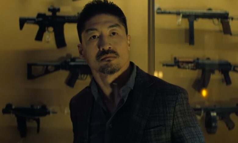 Zachary Beck holding a gun in Reacher Season 3.