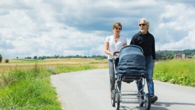 grootouders wandelen op landweg met kinderwagen