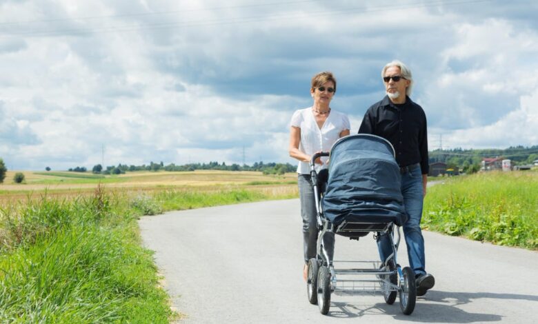 grootouders wandelen op landweg met kinderwagen