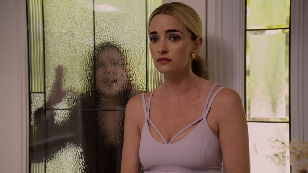 A Geórgia fica na frente de uma janela enquanto uma mulher desconhecida atinge